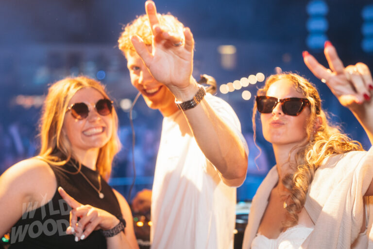 Beim Wild Woods Festival im Märchenwald: warmes Bühnenlicht, Sonnenbrillen und ausgelassene Tanzstimmung inmitten einer elektronischen Nacht.